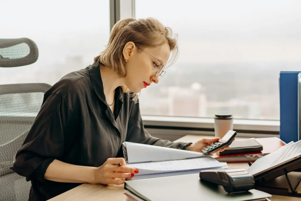 Vrouw aan het werk als financial controller / business controller achter haar bureau oop kantoor